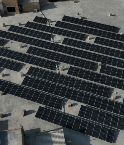 Rows of solar panels mounted across a concrete rooftop