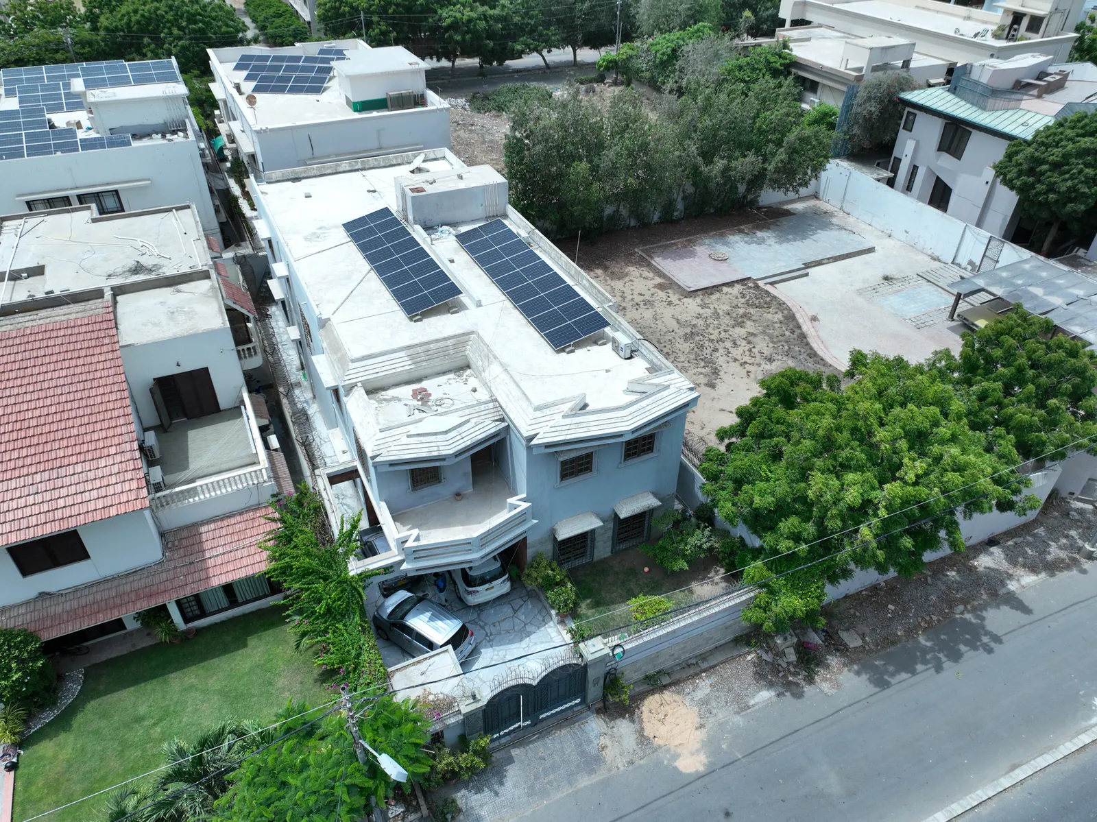 Solar panels on a house rooftop surrounded by trees and neighbouring homes
